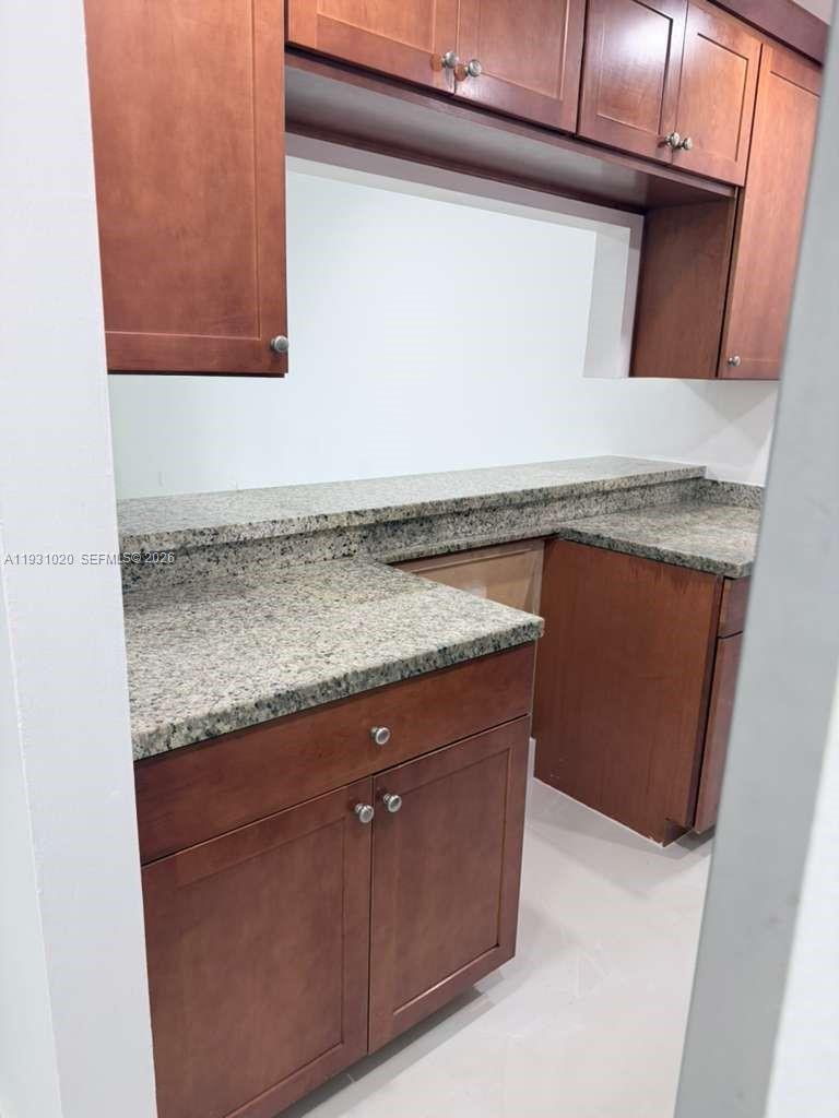 160 Southwest 30th Avenue, Unit 104A Miami, FL 33135 - Photo 10 of 32 a bathroom with a granite countertop sink and a mirror