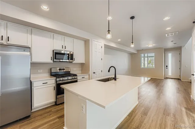 a kitchen with kitchen island a sink appliances and cabinets