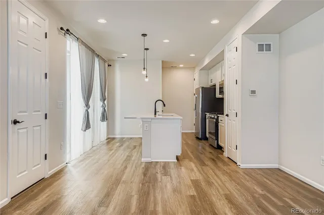 a view of a kitchen with a sink and wooden floor