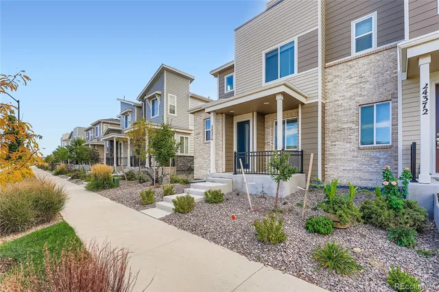 a front view of a house with garden and plants