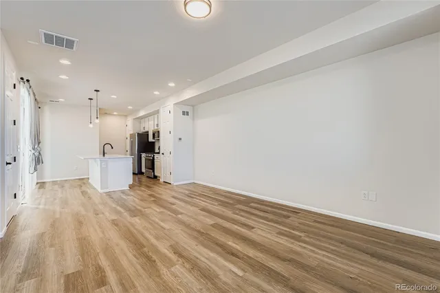 a view of an empty room with wooden floor