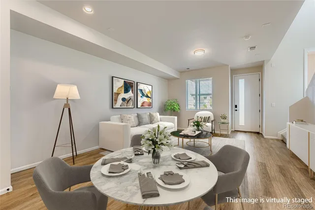 a living room with furniture a dining table and a chandelier