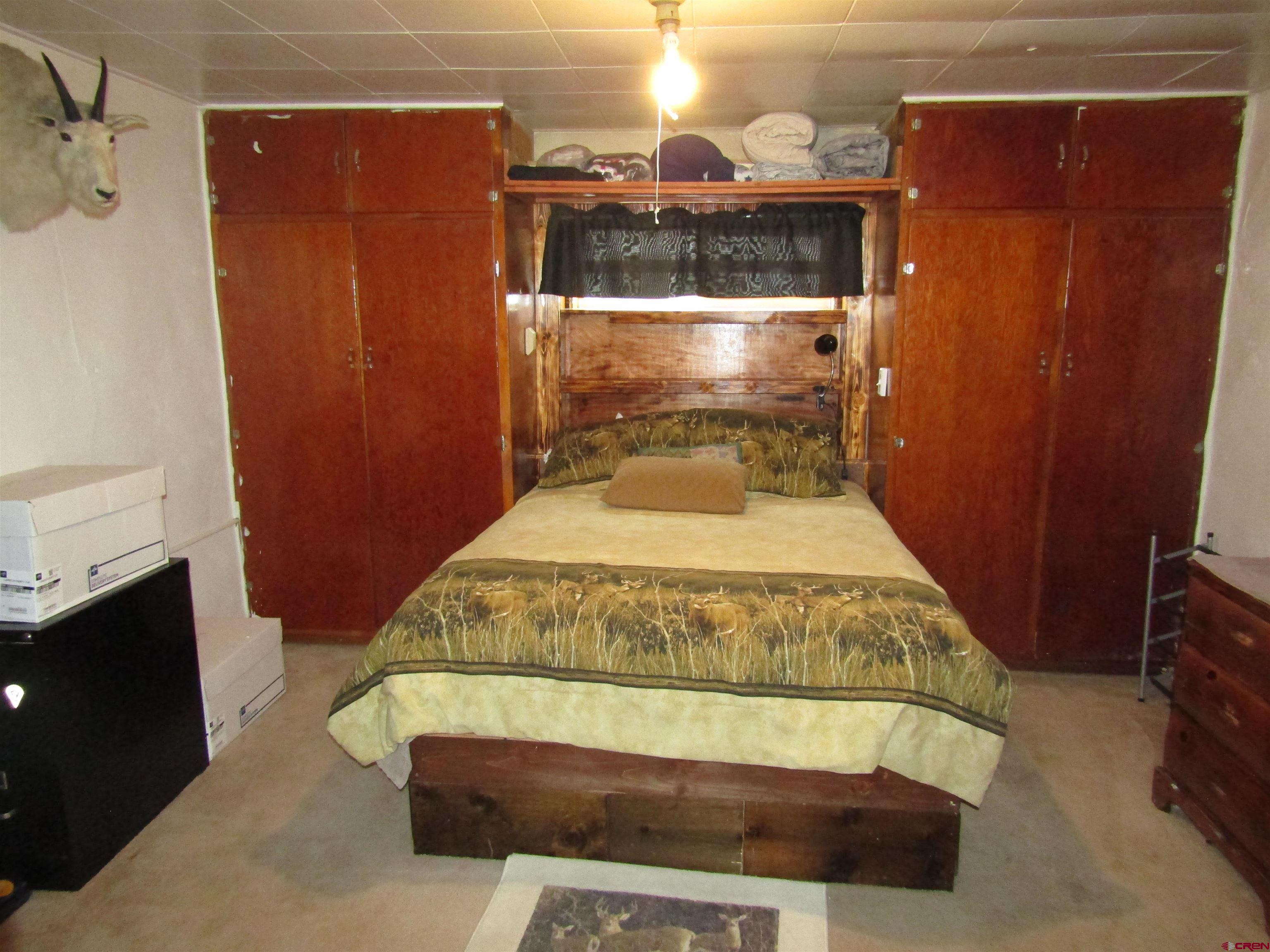 412 Lariat Road Monte Vista, CO 81144 - Photo 6 of 12 a bedroom with a bed and a mirror