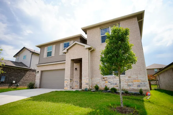 a front view of a house with a yard and trees