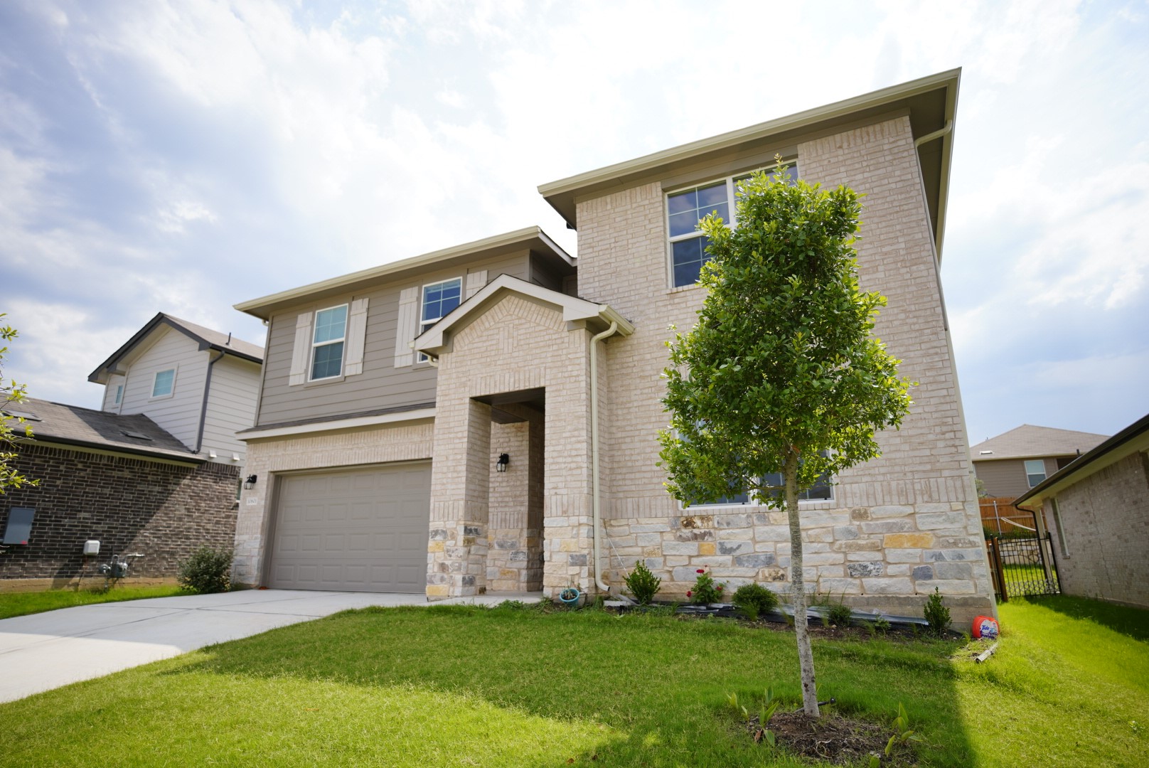 a front view of a house with a yard and trees