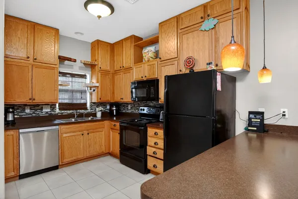 a kitchen with stainless steel appliances granite countertop a refrigerator a stove and a sink