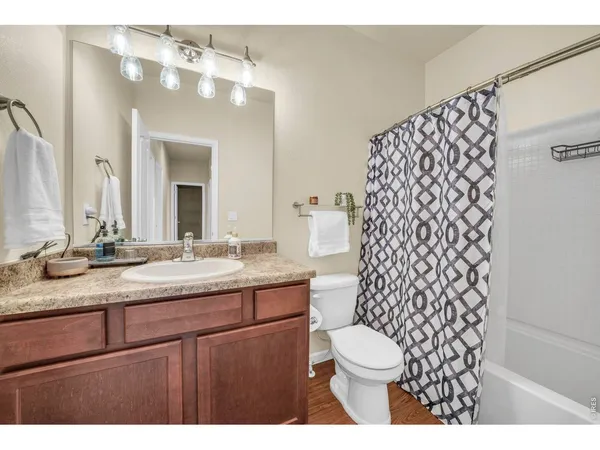a bathroom with a granite countertop double vanity sink mirror and toilet