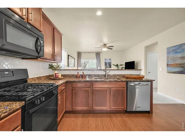 a kitchen with stainless steel appliances a sink a stove a microwave a sink and cabinets