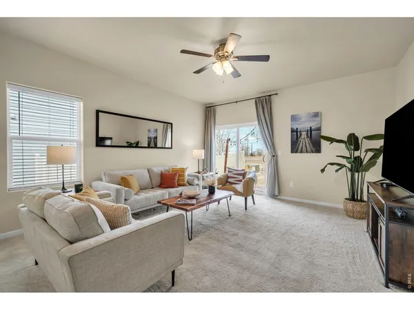 a living room with furniture a flat screen tv and a window