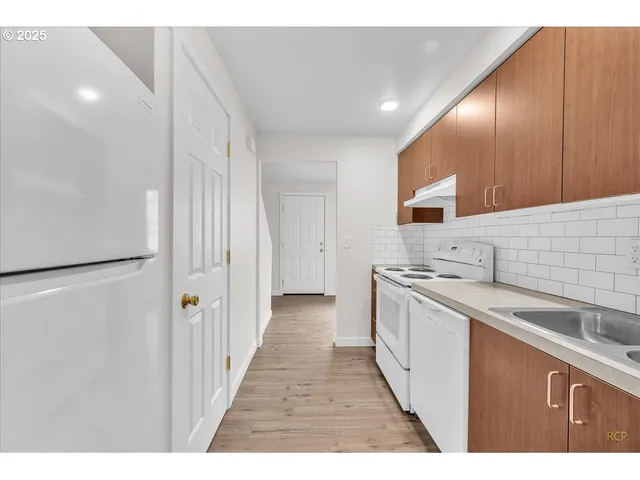 a kitchen with stainless steel appliances granite countertop a sink and a refrigerator