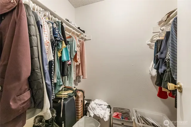 a view of walk in closet with clothes