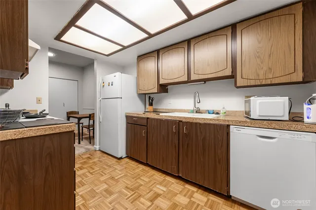 a kitchen with granite countertop wooden cabinets stainless steel appliances a sink and a window