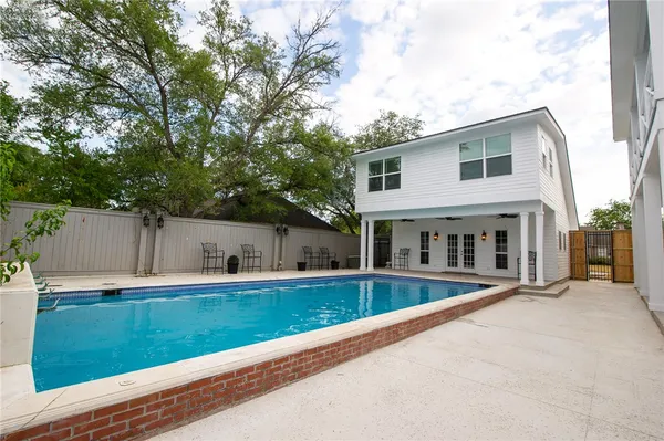 a view of a house with a swimming pool and a yard