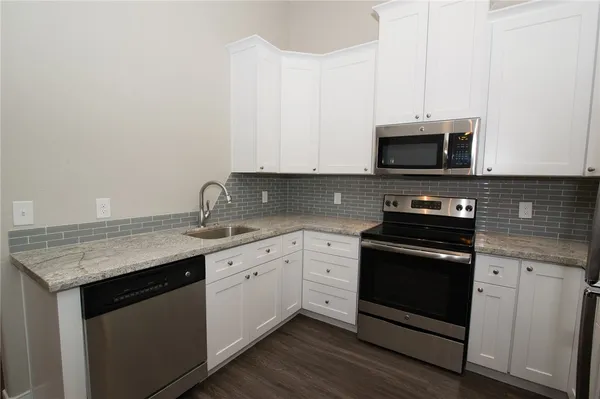 a kitchen with stainless steel appliances granite countertop a stove microwave and sink