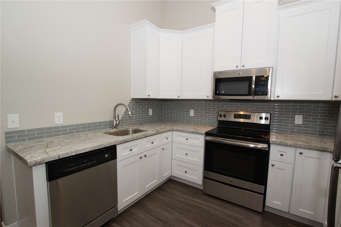 701 Hereford Street, Unit GARAGE APARTMENT College Station, TX 77840 - Photo 5 of 14 a kitchen with stainless steel appliances granite countertop a stove microwave and sink