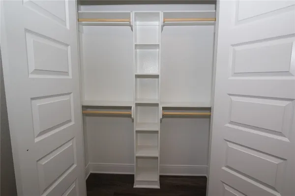 a view of walk in closet with empty racks
