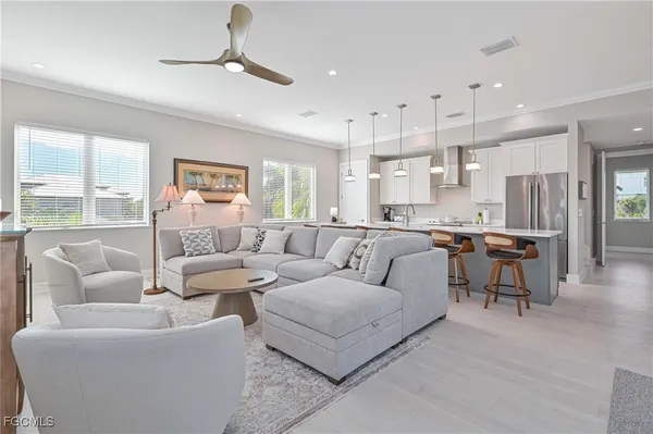 a living room with furniture kitchen and a chandelier