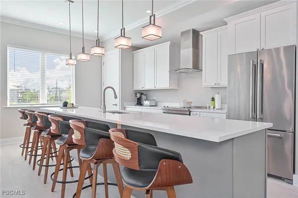 a kitchen with a dining table chairs sink and refrigerator
