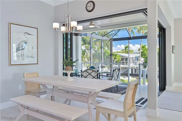 a dining room with wooden floor a chandelier a glass table and chairs