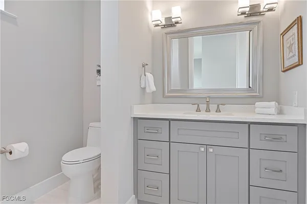 a bathroom with a toilet a sink a vanity and mirror