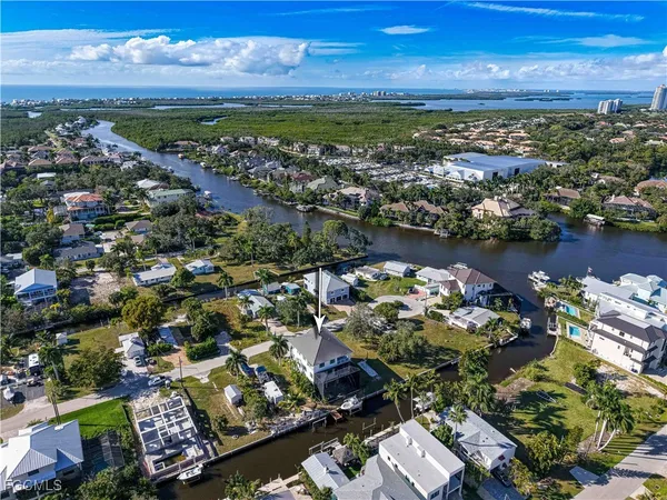 an aerial view of a city with lots of residential buildings ocean and mountain view in back