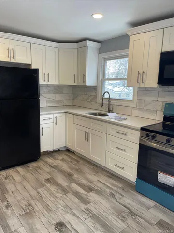 a kitchen with granite countertop a sink stainless steel appliances and cabinets