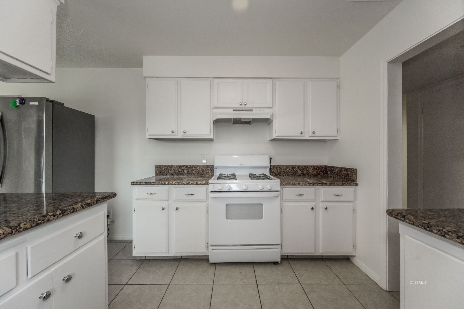 412 East Church Avenue Ridgecrest, CA 93555 - Photo 6 of 39 a kitchen with granite countertop white cabinets and white appliances