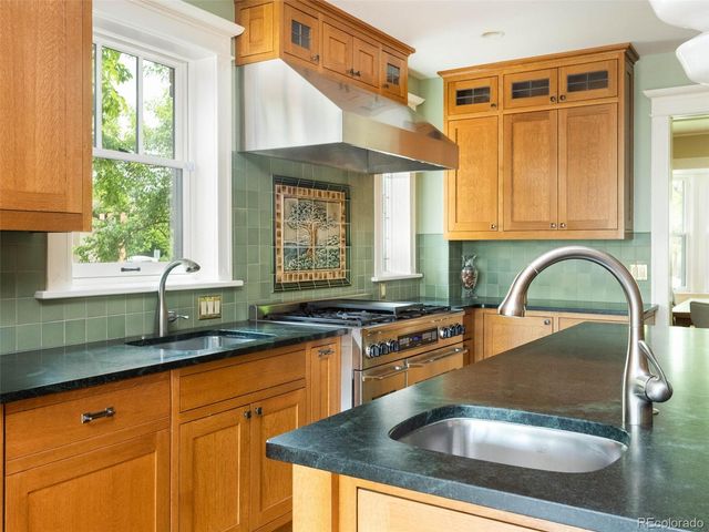 a kitchen with granite countertop a sink a counter and cabinets