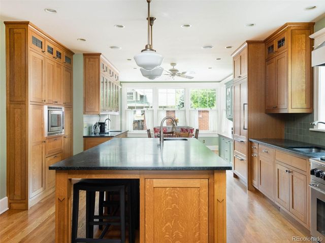 a kitchen with stainless steel appliances granite countertop a sink a stove and refrigerator