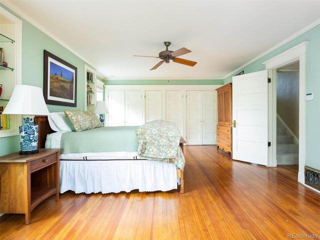 a living room with a bed furniture and a wooden floor