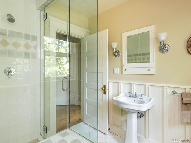 a bathroom with a sink shower and a mirror