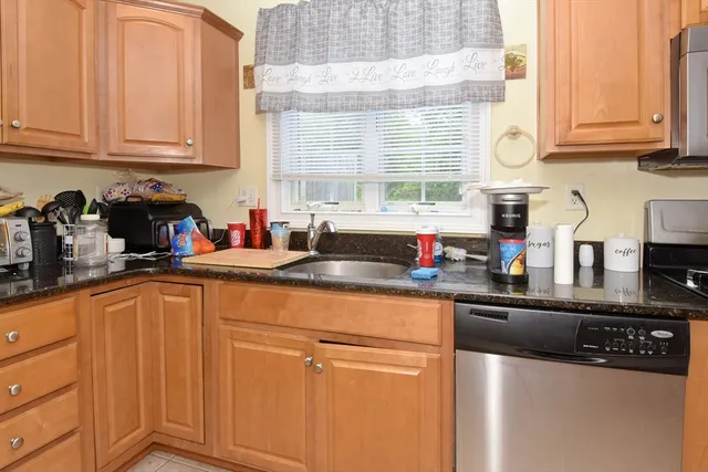 a kitchen with stainless steel appliances granite countertop a sink a stove and cabinets