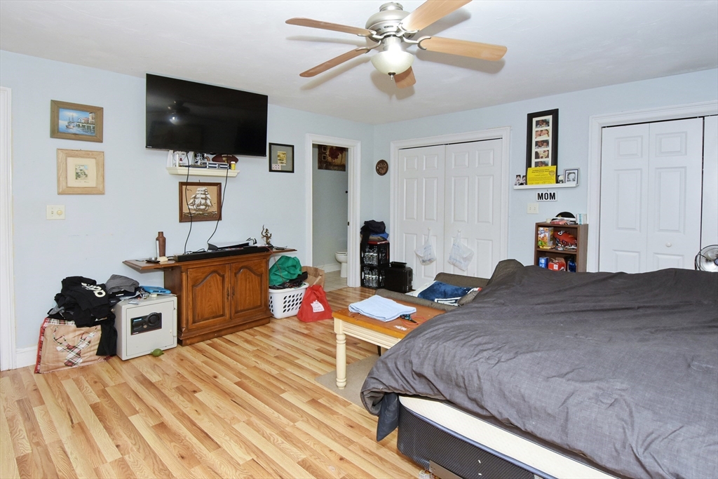 966 Washington Street, Unit 2 Weymouth, MA 02189 - Photo 13 of 25 a bedroom with a bed a flat screen tv and a couch