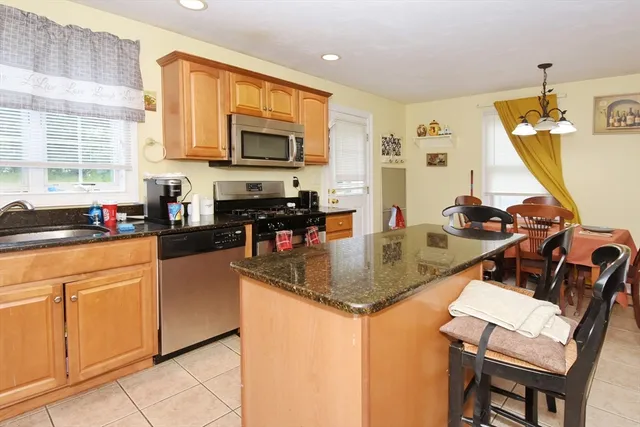 a kitchen with stainless steel appliances granite countertop a sink a stove a microwave a refrigerator and cabinets