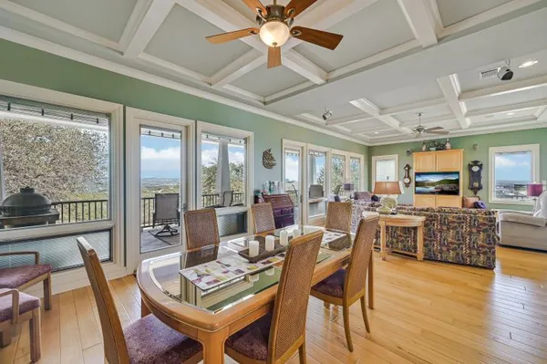 a dining room with furniture a chandelier and wooden floor