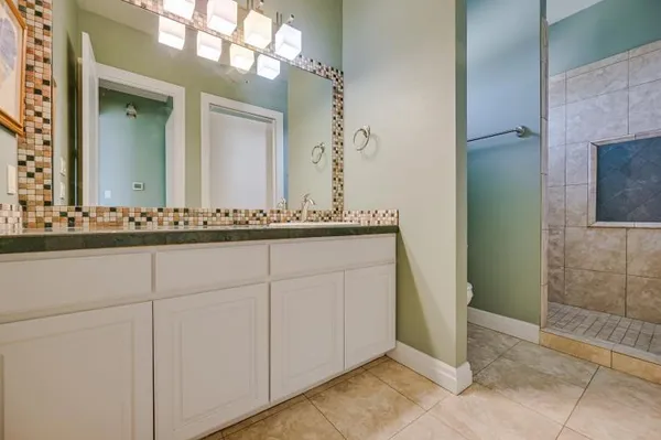 a spacious bedroom with a bed and a chandelier