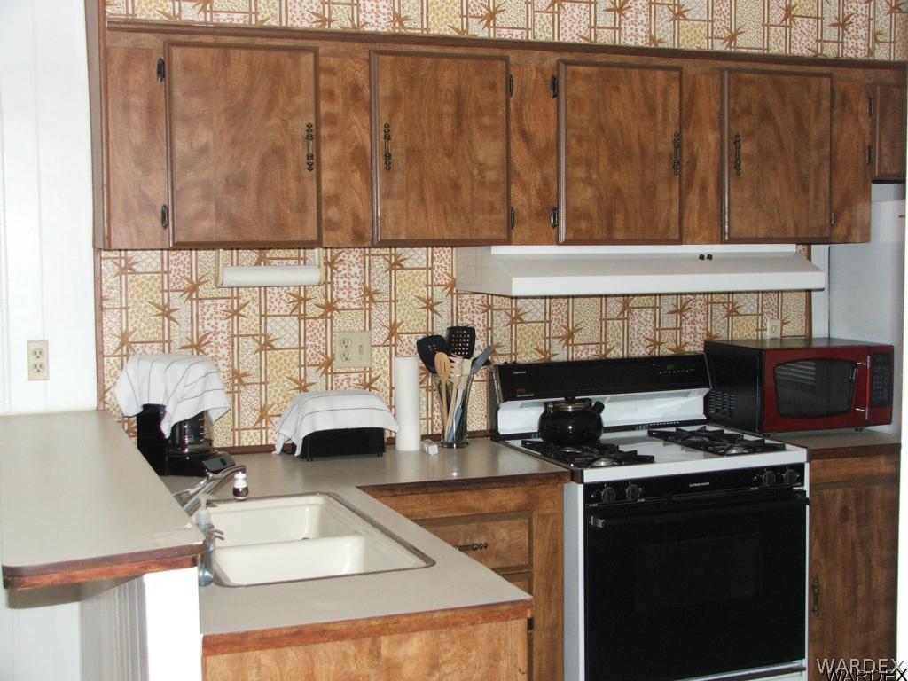 1663 East Gran Fort Mohave, AZ 86426 - Photo 10 of 34 a kitchen with a sink a stove and a wooden cabinets