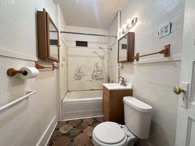 a white toilet sitting next to a bath tub
