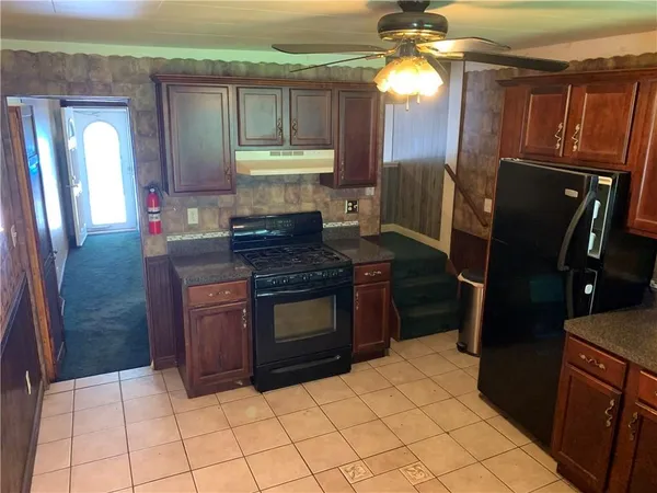 a kitchen with stainless steel appliances granite countertop a refrigerator a stove and a sink
