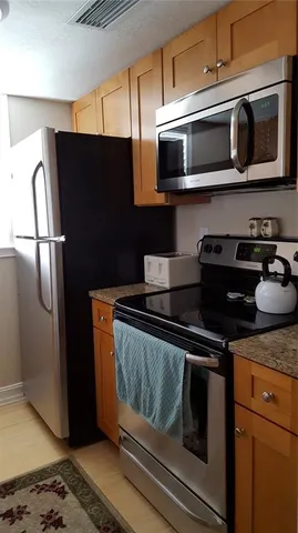 a kitchen with stainless steel appliances granite countertop a refrigerator and a microwave