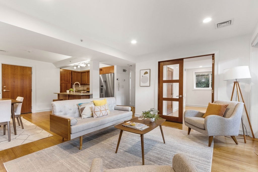 a living room with furniture and a wooden floor