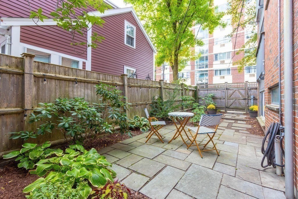 27 West Street, Unit 1 Cambridge, MA 02139 - Photo 15 of 26 a view of a patio with a table and chairs and potted plants