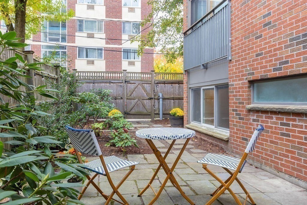 27 West Street, Unit 1 Cambridge, MA 02139 - Photo 17 of 26 a view of a chair and table in the back yard of the house