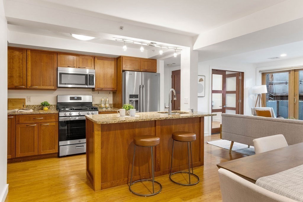 27 West Street, Unit 1 Cambridge, MA 02139 - Photo 5 of 26 a kitchen with stainless steel appliances granite countertop a stove and a refrigerator