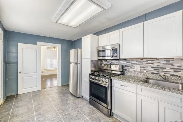 a kitchen with stainless steel appliances granite countertop a refrigerator stove and sink