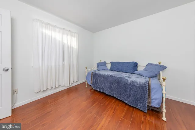 a room with a bed and wooden floor