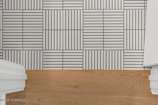 a view of a house with a yard plants and large tree