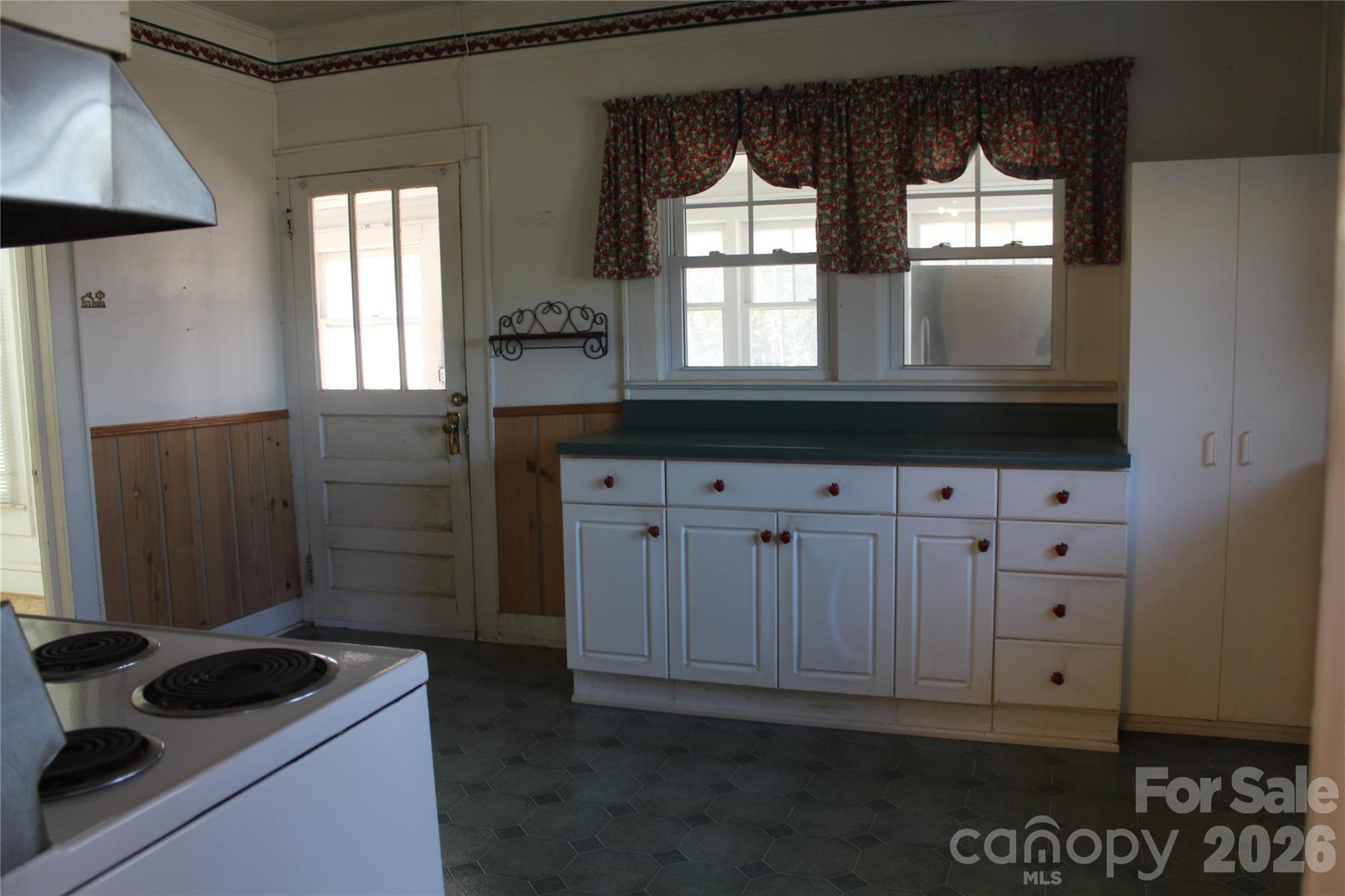 113 Williams Street Morganton, NC 28655 - Photo 7 of 20 a kitchen with white cabinets and a stove