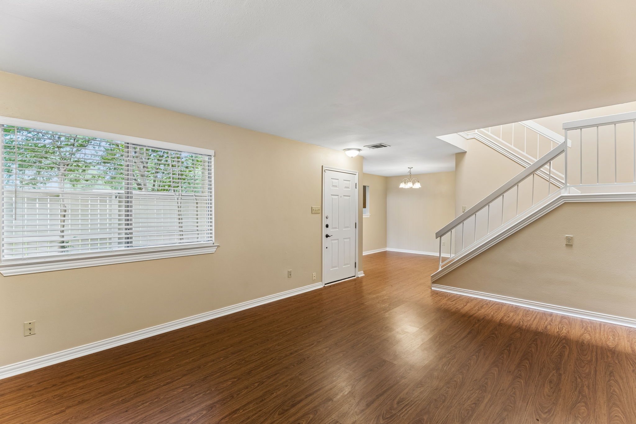 8340 Fathom Circle, Unit 103 Austin, TX 78750 - Photo 10 of 30 a view of an empty room with wooden floor and a window