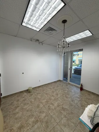 an empty room with windows and ceiling fan